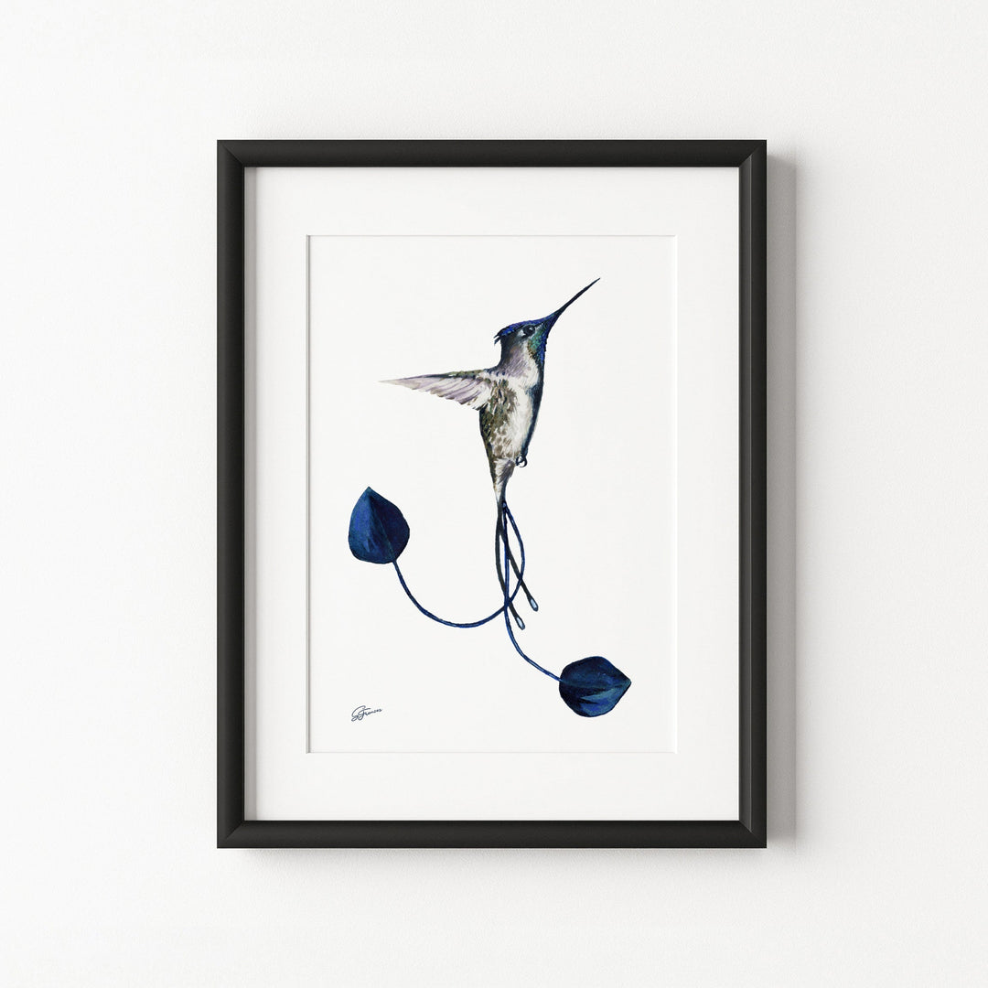 Framed artwork of a hummingbird and blue flowers on a white wall
