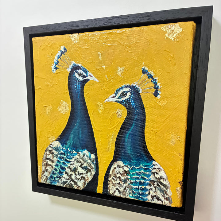 Framed artwork of two peacocks on a yellow background
