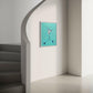 humming bird painting on a dusty green hue canvas , in a white frame on a white staircase wall