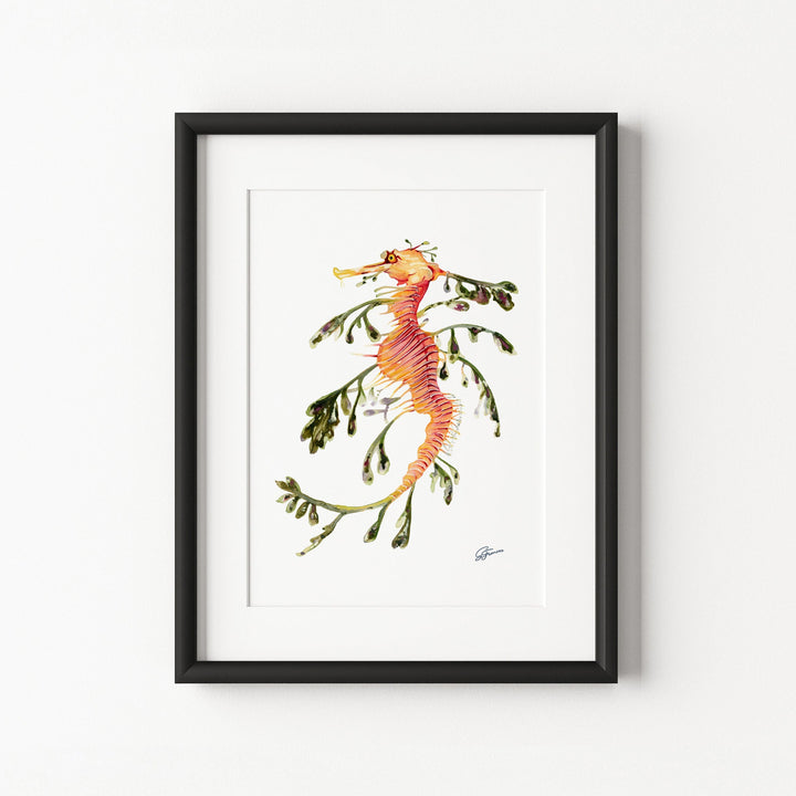 Framed artwork of a seahorse with seaweed on a white wall