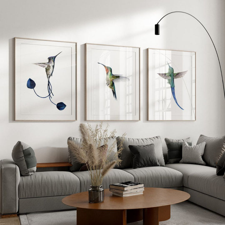 Living room with a gray sectional sofa, wooden coffee table, and wall art of hummingbirds.
